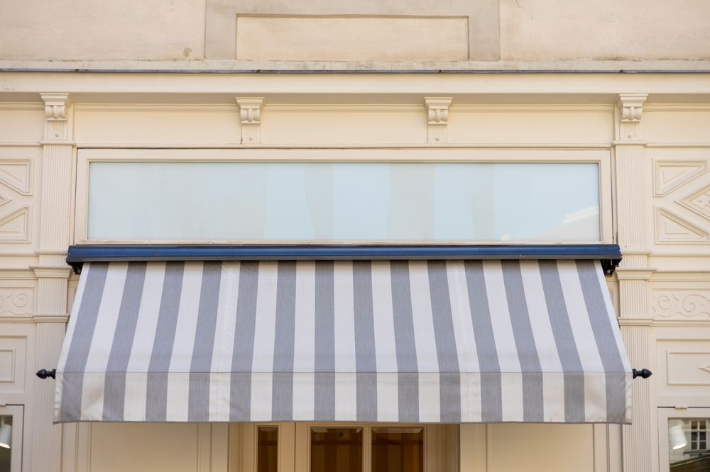 A store front with a striped awning over a window.