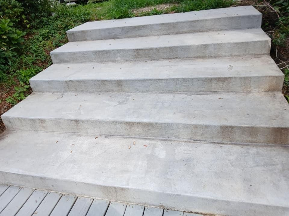 Concrete outdoor steps leading upwards, with some grass visible in the background.