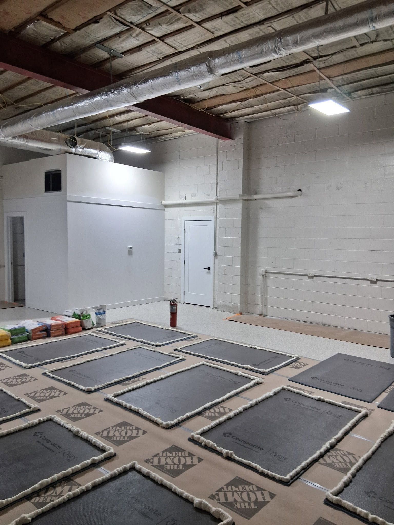 Empty bright industrial warehouse with white walls, high ceiling, and large open floor