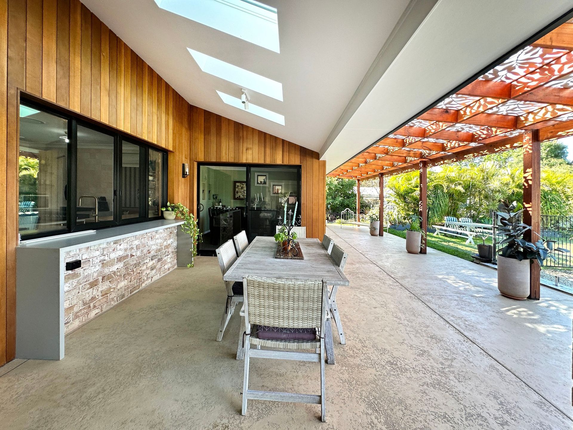 Outdoor Patio With Dining Table, Wooden Accents, and Lush Greenery — BK Building Services Pty Ltd In Taree, NSW