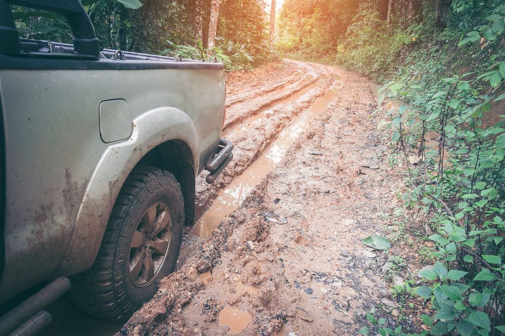 Person Wearing a Glove Works on a Car's Suspension — Ottos Mufflers in Noosaville, QLD