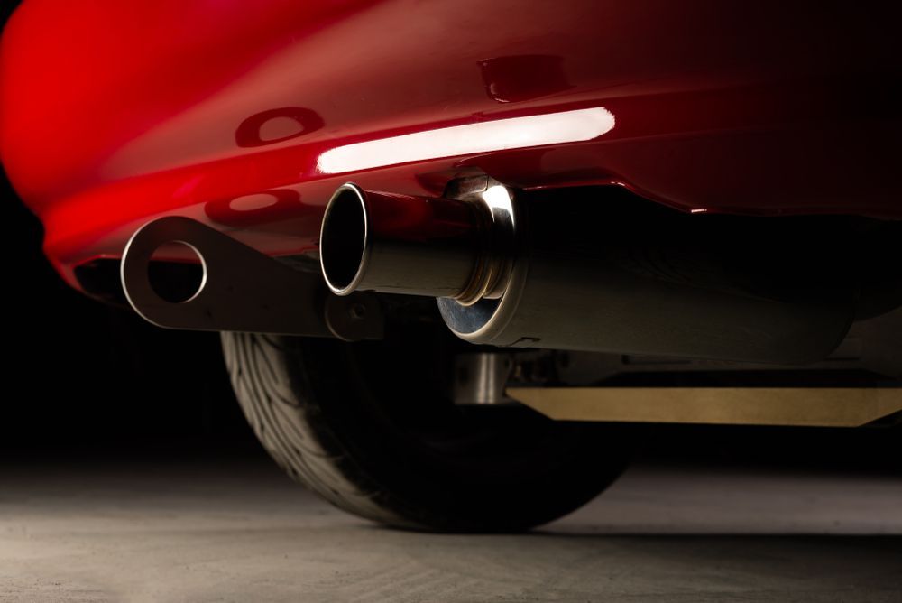 Red Car's Exhaust Pipes: Two Round and One Oval Exit, Chrome Finish — Ottos Mufflers in Noosaville, QLD