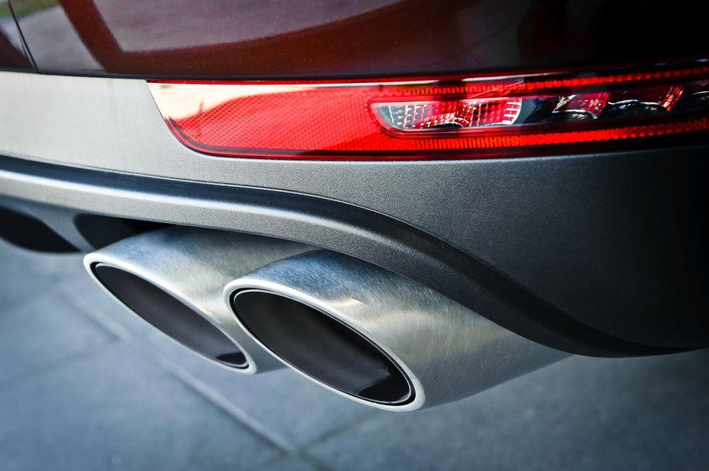 Close-up of a Car's Dual Exhaust Pipes and Red Tail Light — Ottos Mufflers in Noosaville, QLD