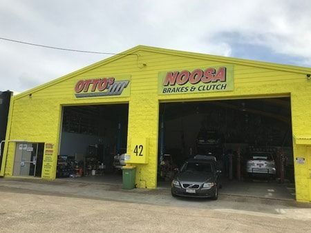 Yellow auto repair shop with open bays,