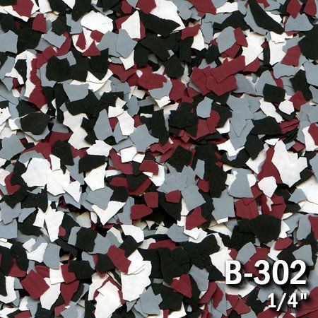 Close-up of decorative floor flakes. Colors include black, gray, maroon, and white. 