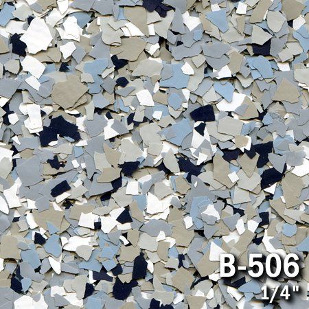 Close-up of multicolored epoxy floor flakes in shades of blue, gray, and white labeled 