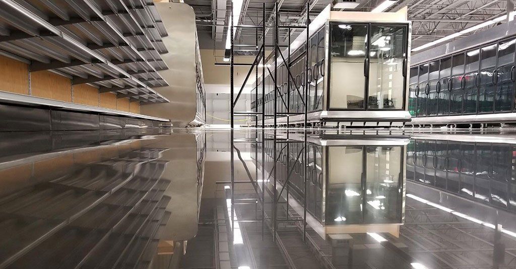 Empty shelves and retail space; glossy, wet floor reflects the interior.