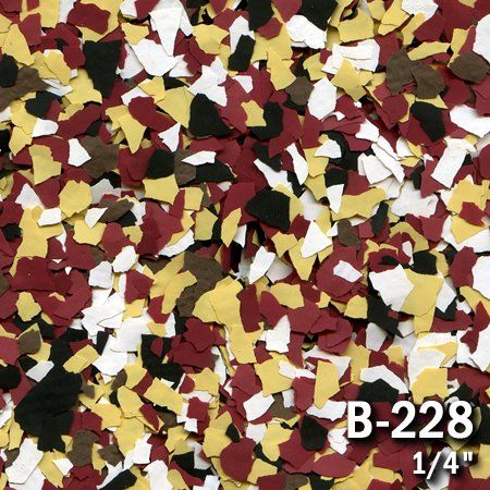 Close-up of multicolored decorative epoxy floor flakes: yellow, white, black, burgundy, and brown.