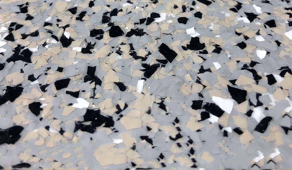 Close-up of a speckled floor with gray, black, tan, and white flakes.