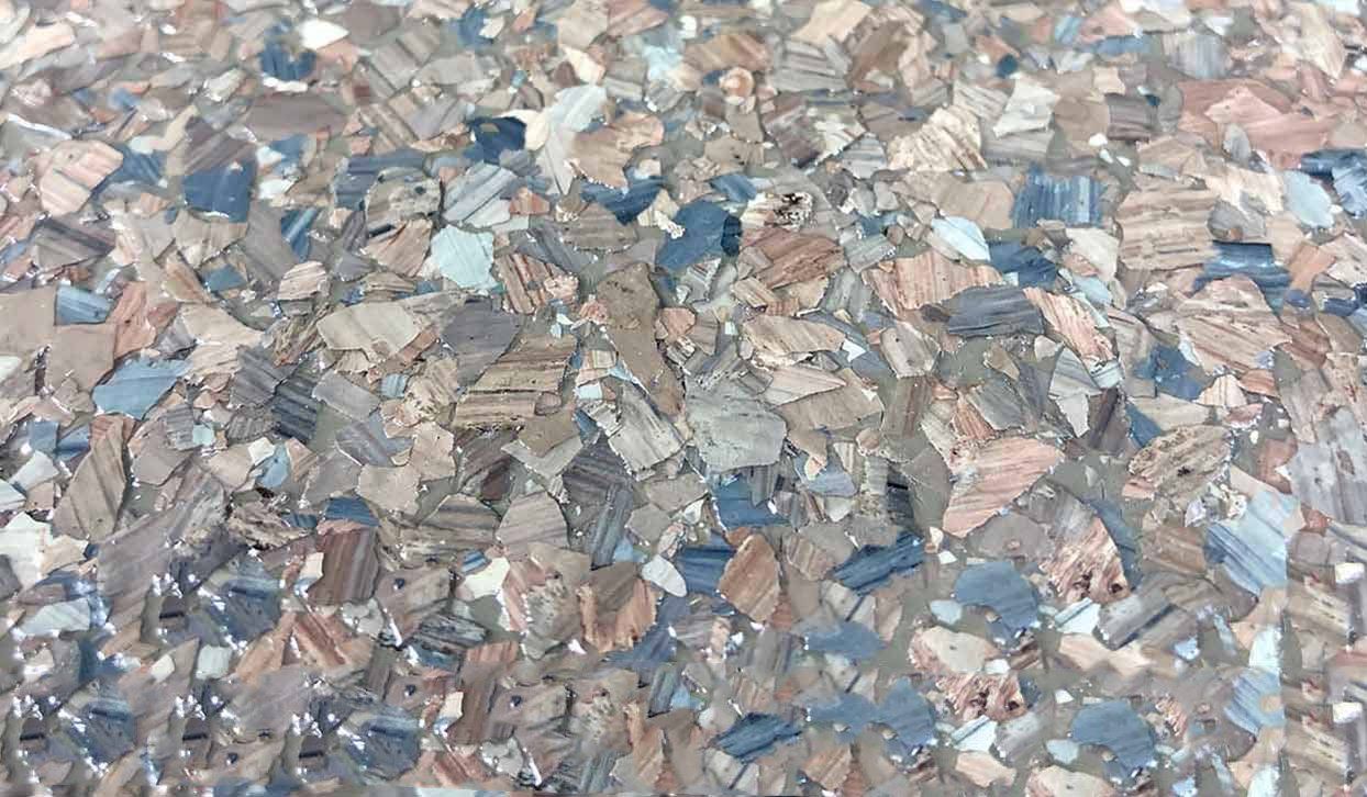 Close-up of cork flooring with a speckled pattern of neutral, blue, and brown tones.
