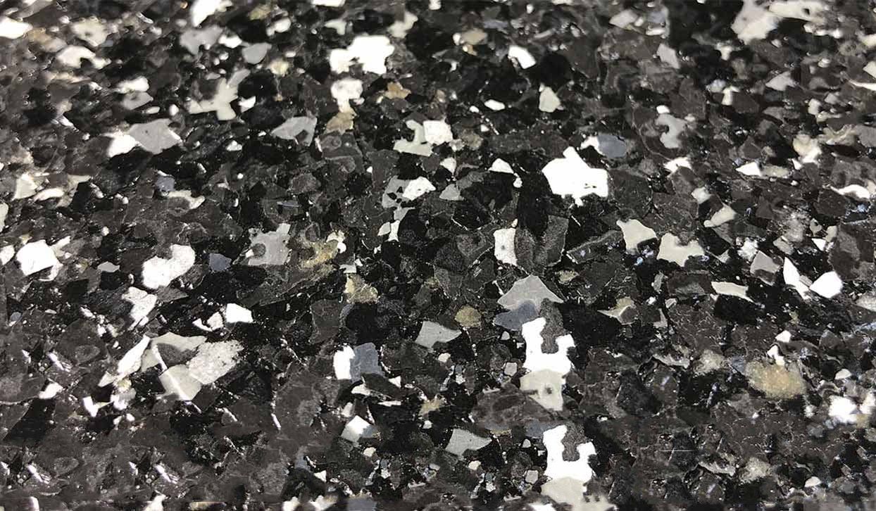 Close-up of a speckled floor coating in black, silver, and white.