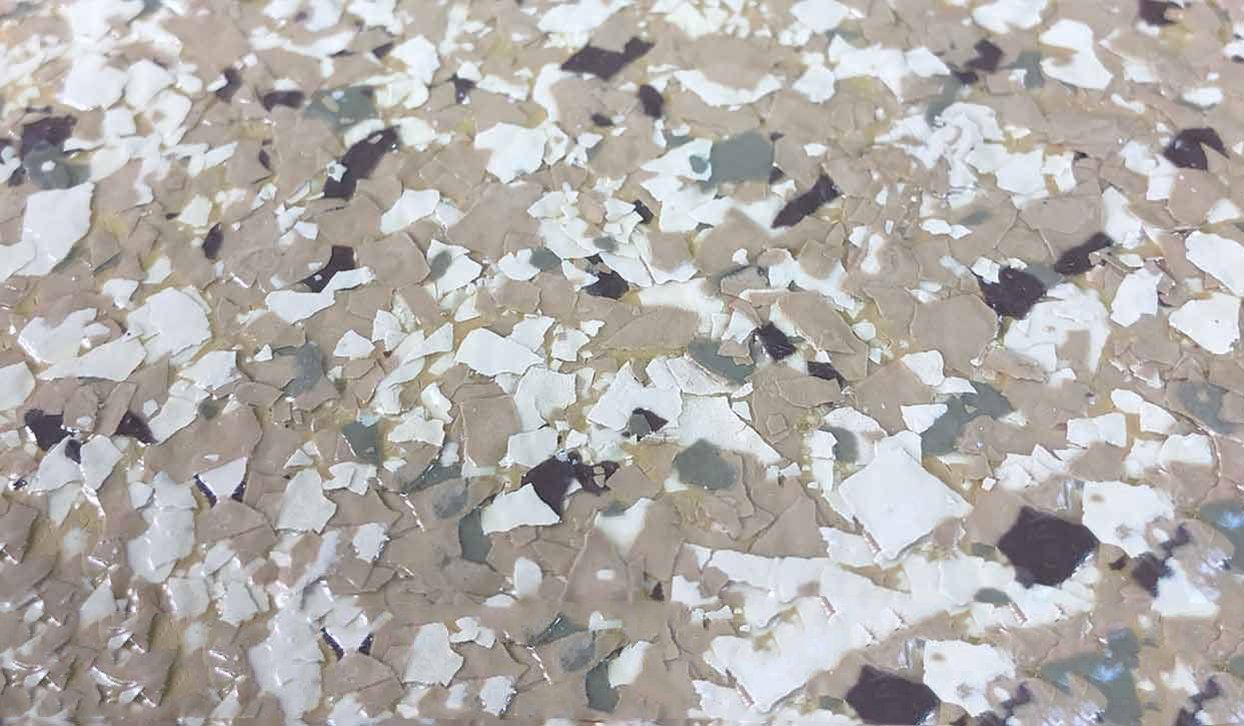 Speckled epoxy floor with white, gray, brown, and dark gray chips.