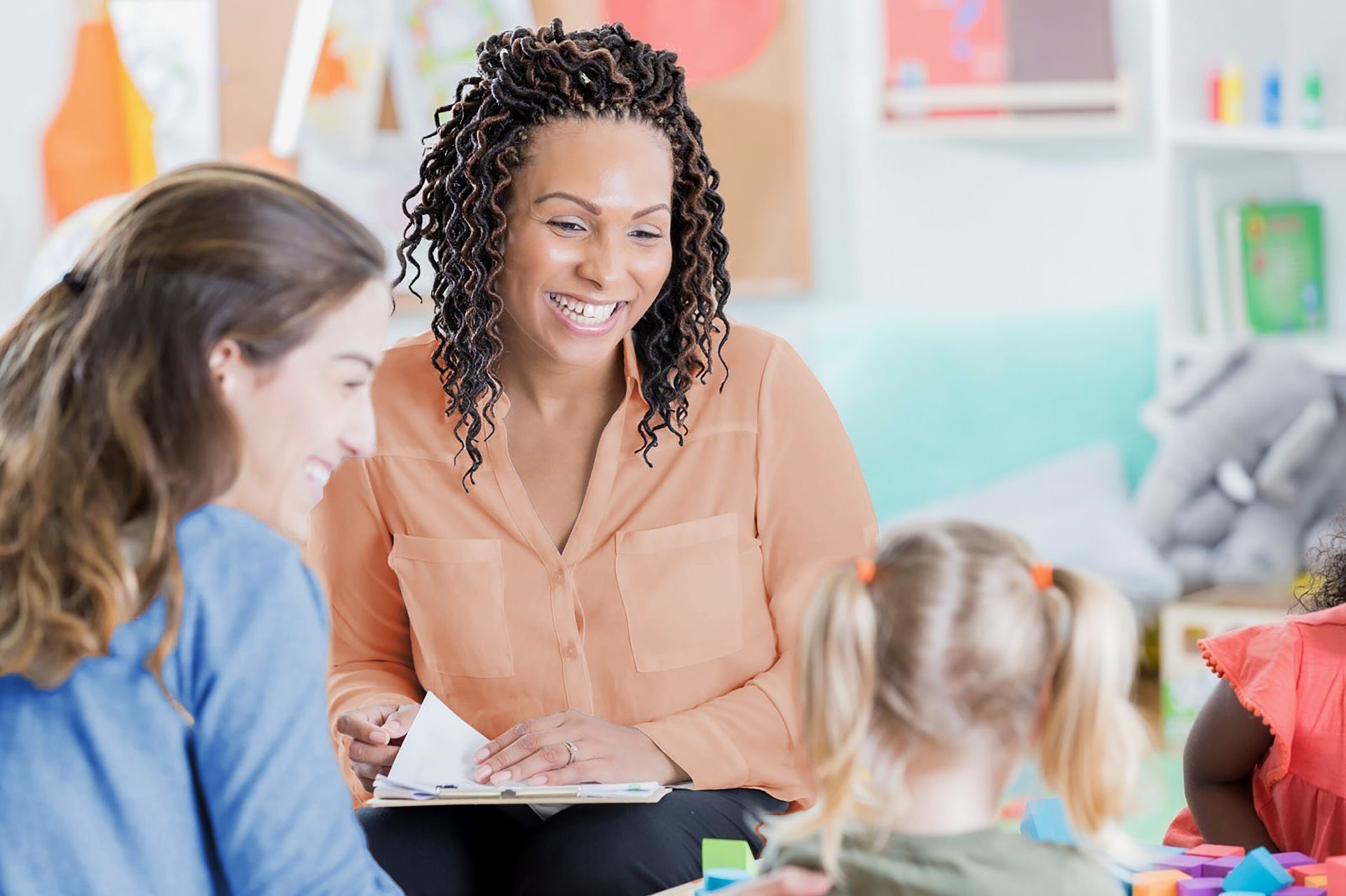 A woman is sitting at a table with two women and a little girl.