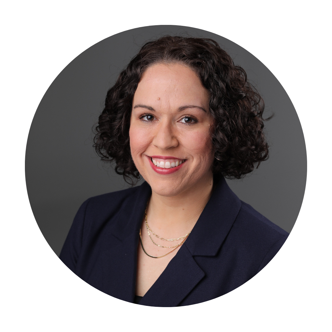 A woman wearing glasses and a suit is smiling in a circle.