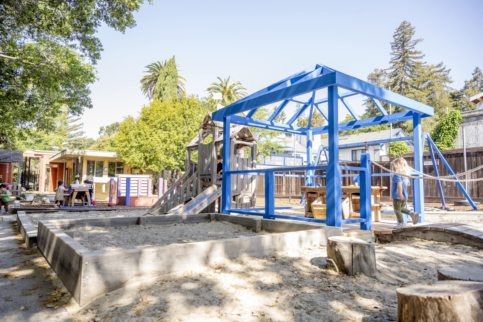 A playground with a blue structure in the middle of it.