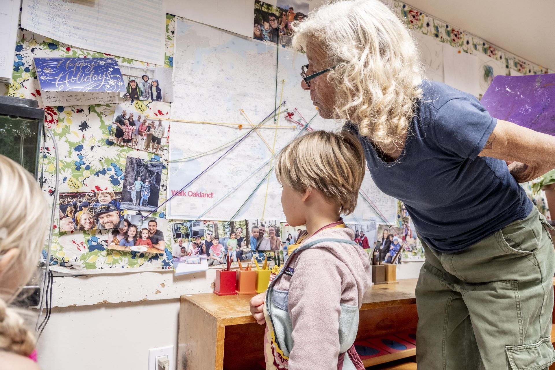 A Montessori guide talking to a child in a classroom.