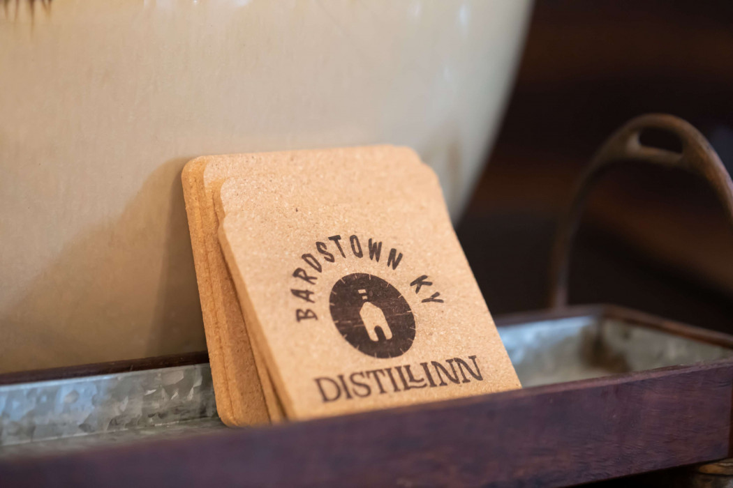 Bartown KY Distilling coaster on a tray beside a white pot
