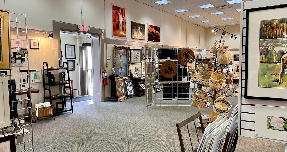 Retail store interior with framed art, home decor, and display shelves under bright ceiling lights