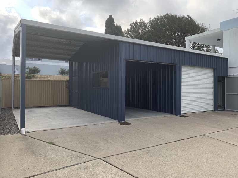 A Blue Garage With A White Door And A Canopy In A Driveway – South Kempsey NSW - Fair Dinkum Builds Macleay Valley Sheds