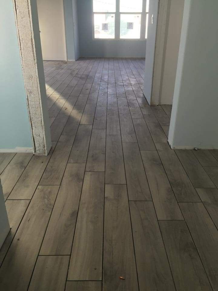 A living room with a wooden floor and a window.