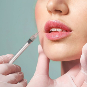 A syringe near a woman’s lips during a cosmetic injection procedure