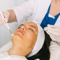 Cosmetic facial treatment with syringes on a reclining woman in a clinic