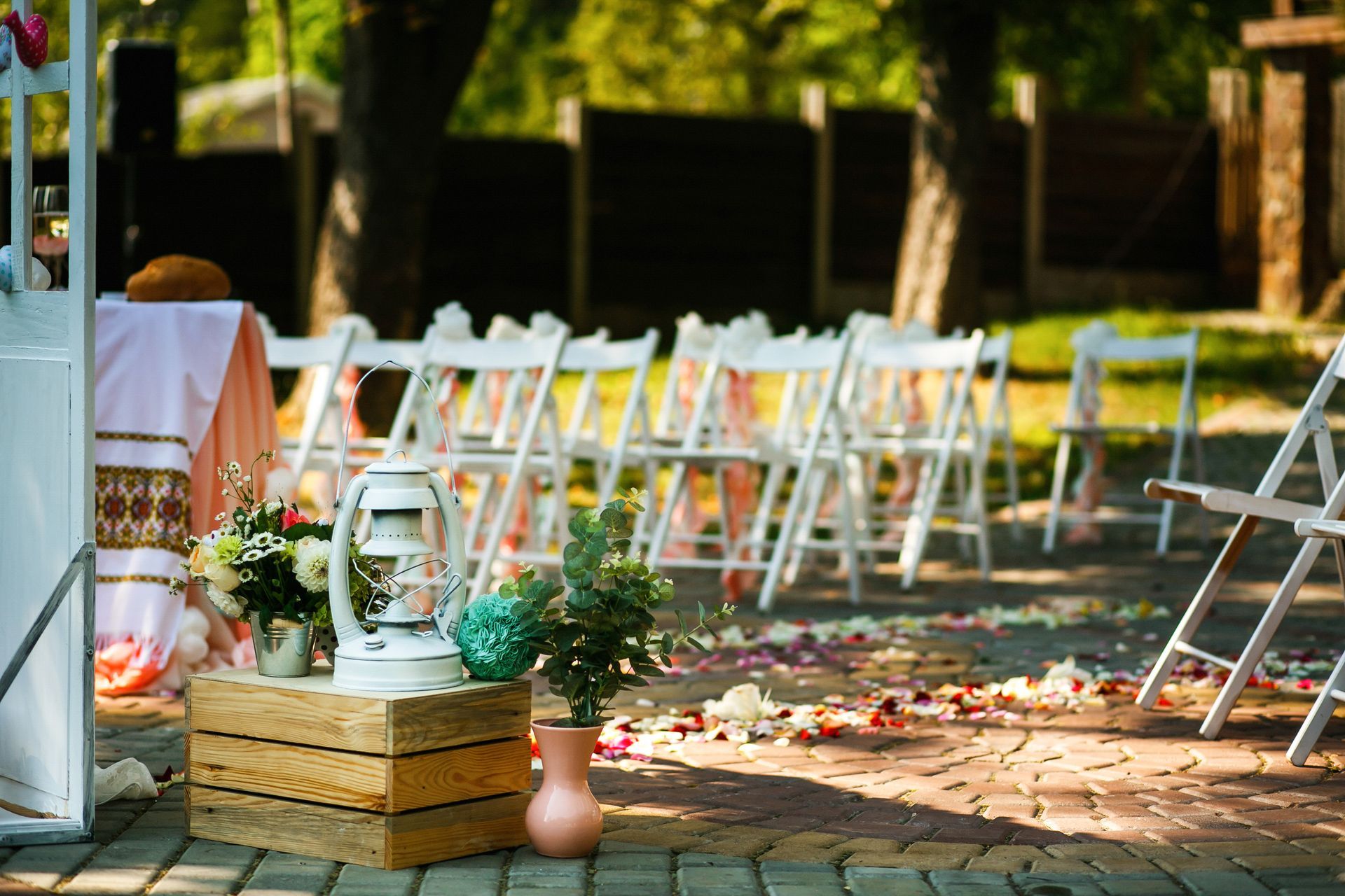 A row of white folding chairs are lined up for a wedding ceremony.