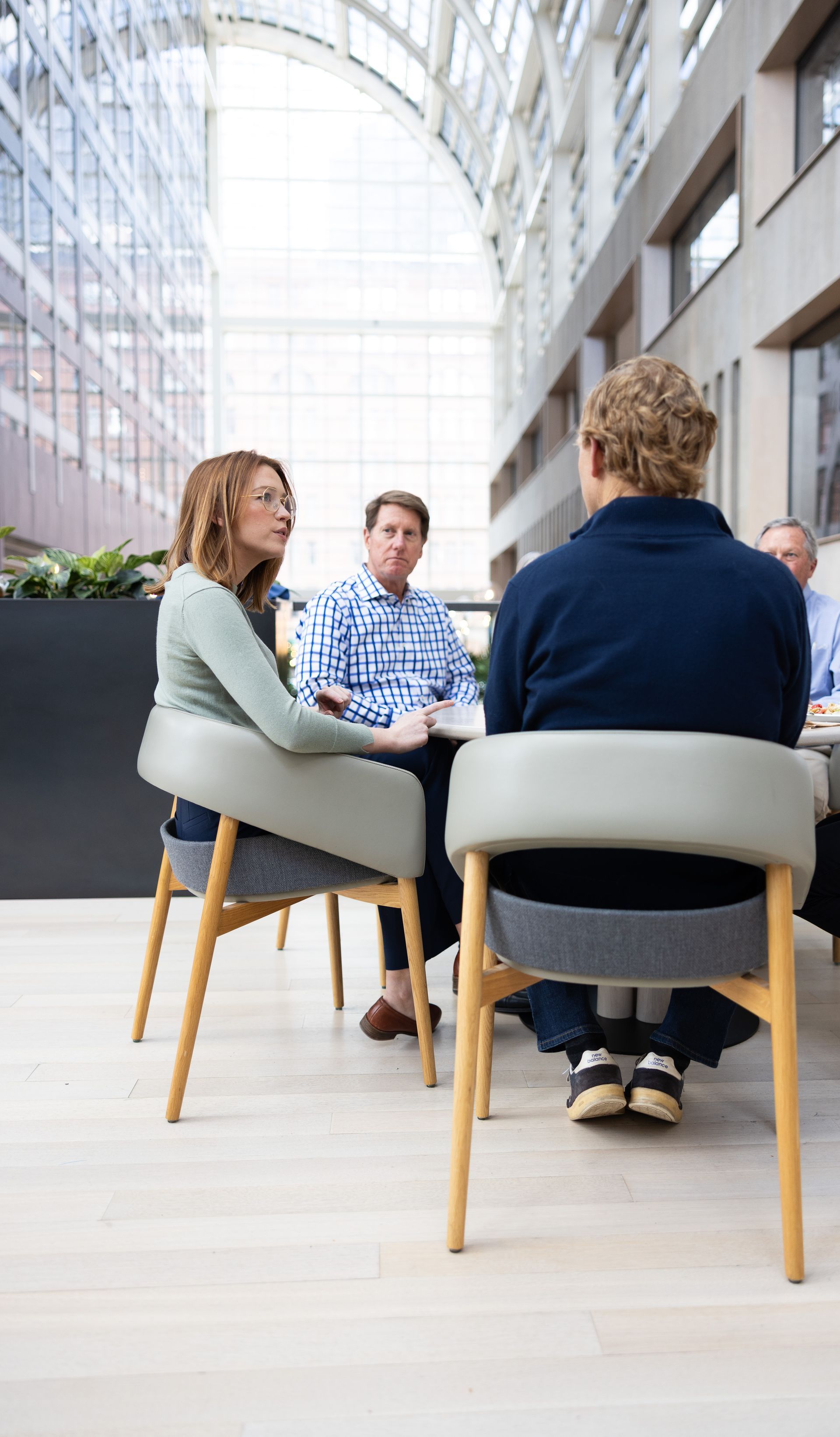 A group of people are sitting around a table having a conversation.