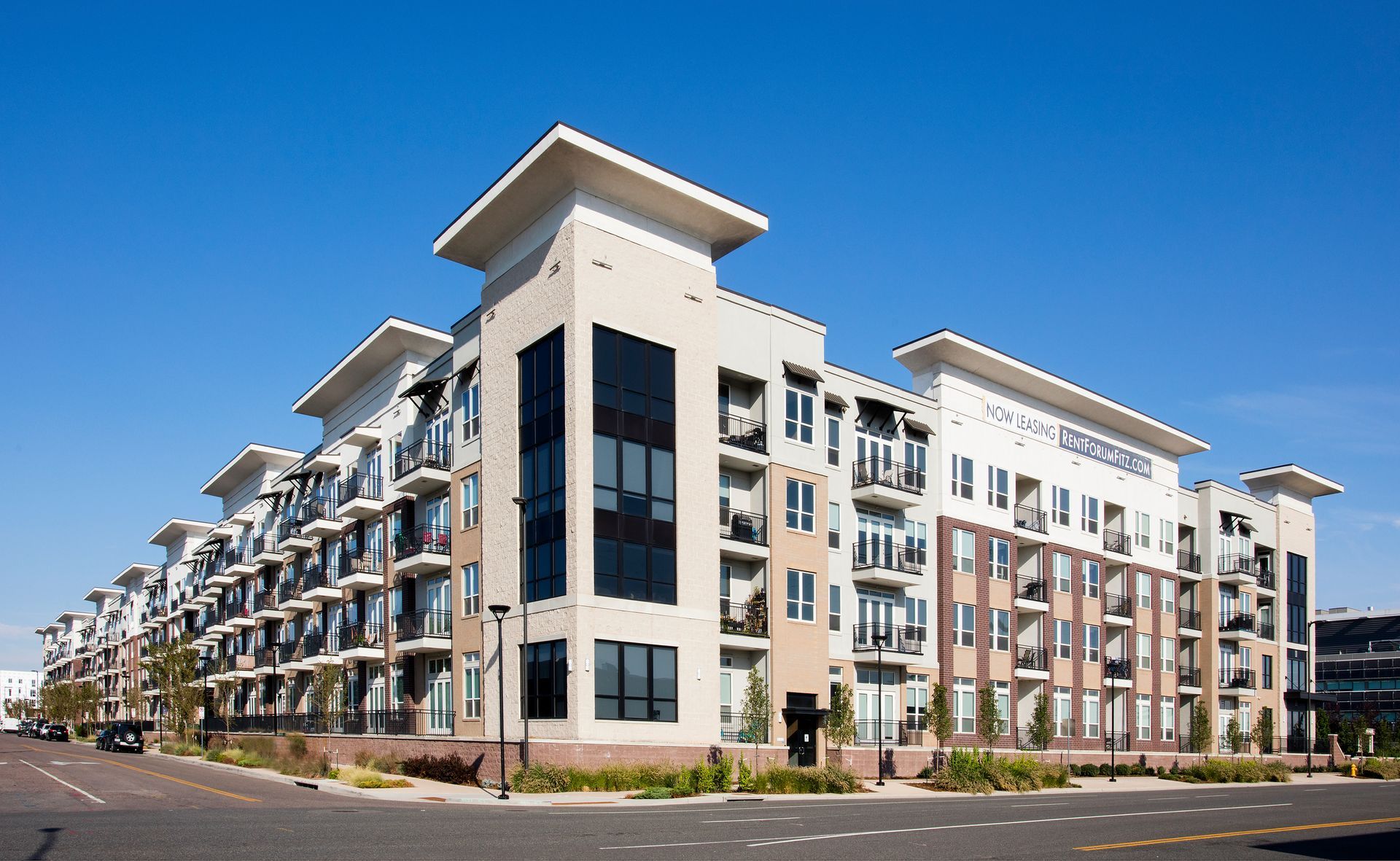 A large apartment building with a blue sky in the background