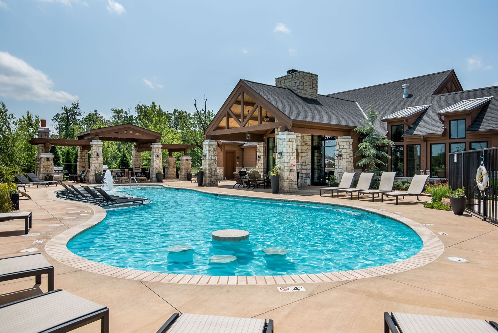 There is a large swimming pool in front of a large house.