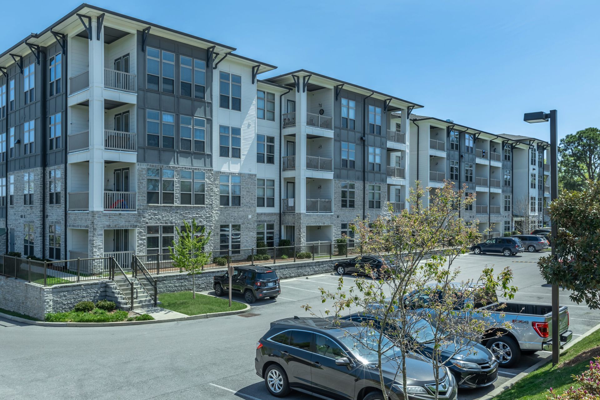 A large apartment building with cars parked in front of it.