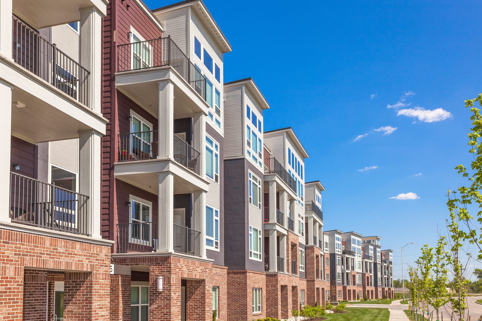 A row of apartment buildings with balconies on a sunny day.
