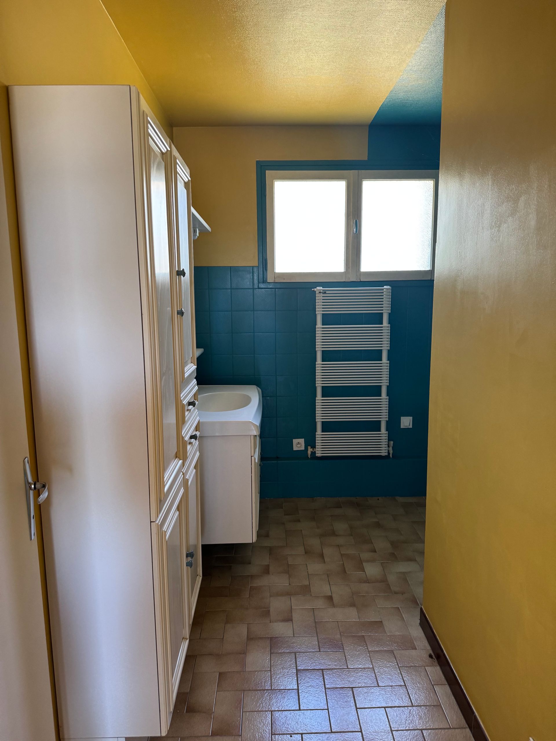 Une pièce vide avec des murs bleus et un sol recouvert de moquette