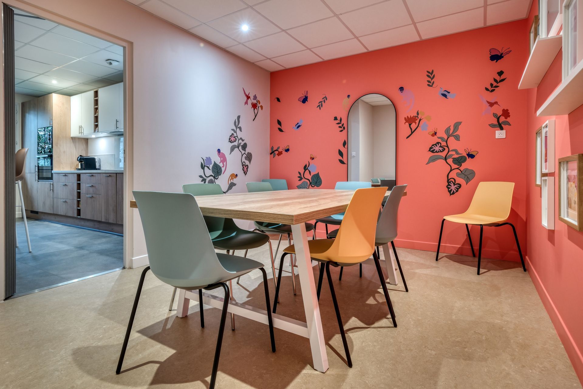 Un groupe de personnes se tient autour de tables et de chaises dans une pièce.