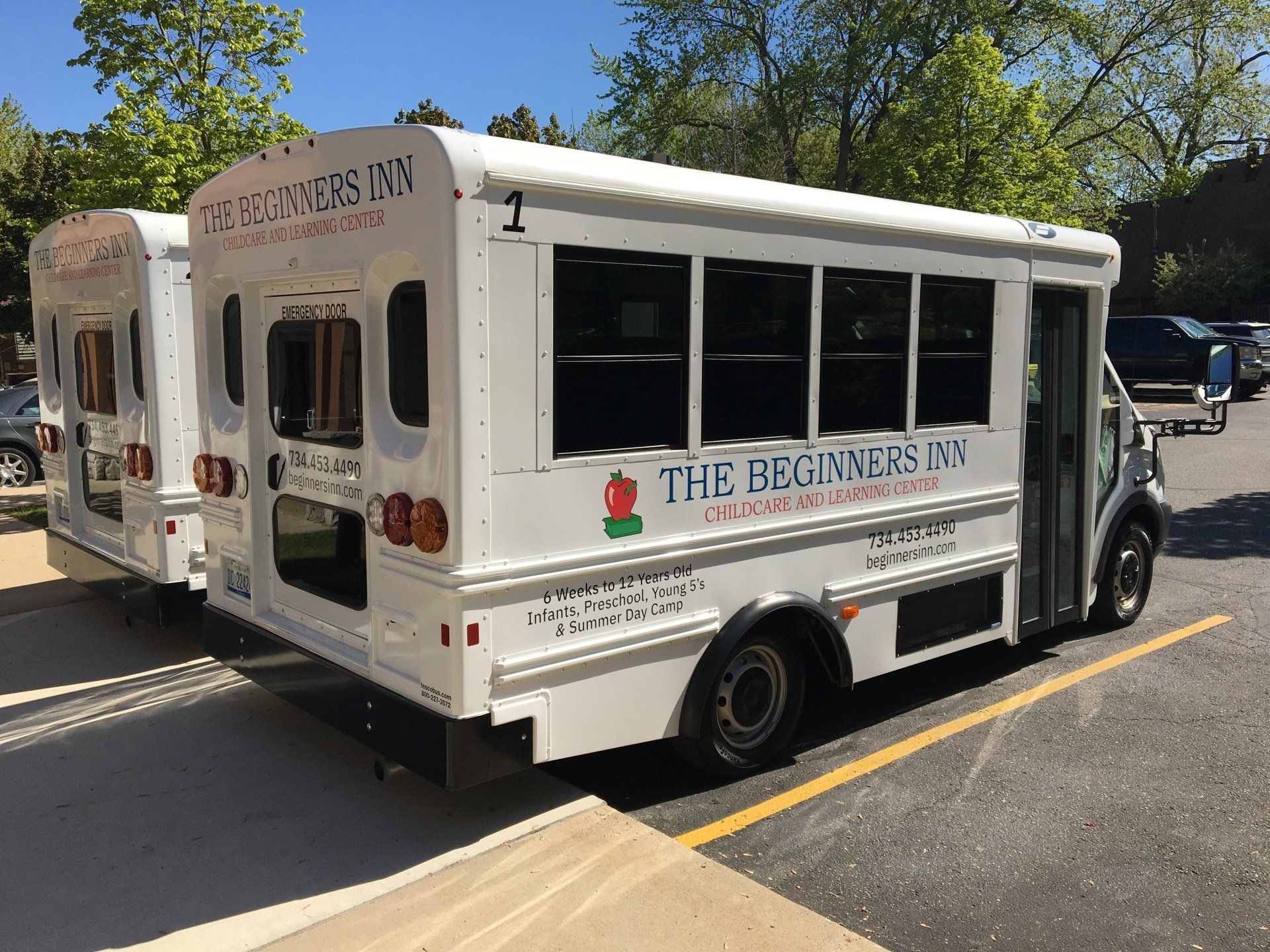 White shuttle bus parked outdoors in a lot on a sunny day