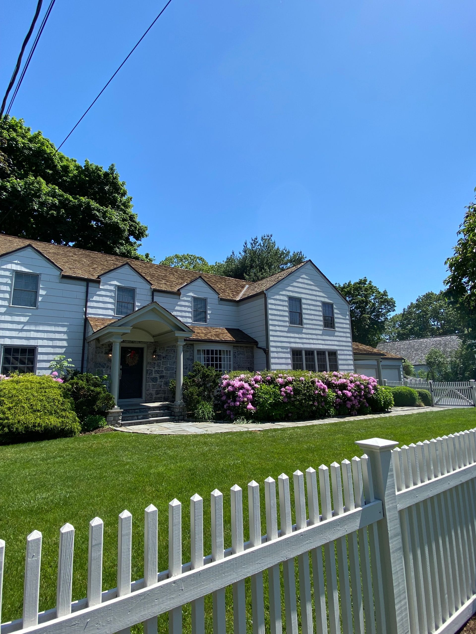 A white house with a white picket fence in front of it