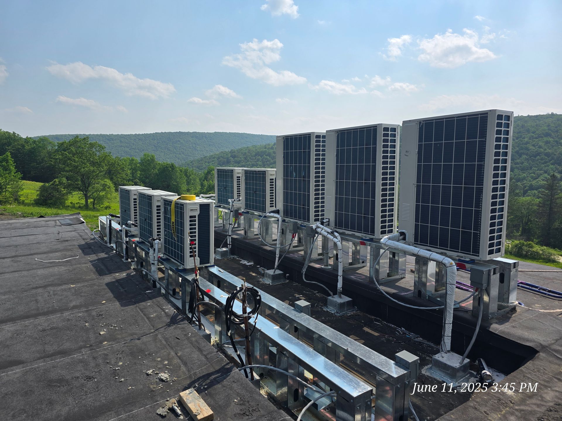 Large industrial cooling units on a trailer, atop a flat surface with a mountainous backdrop.