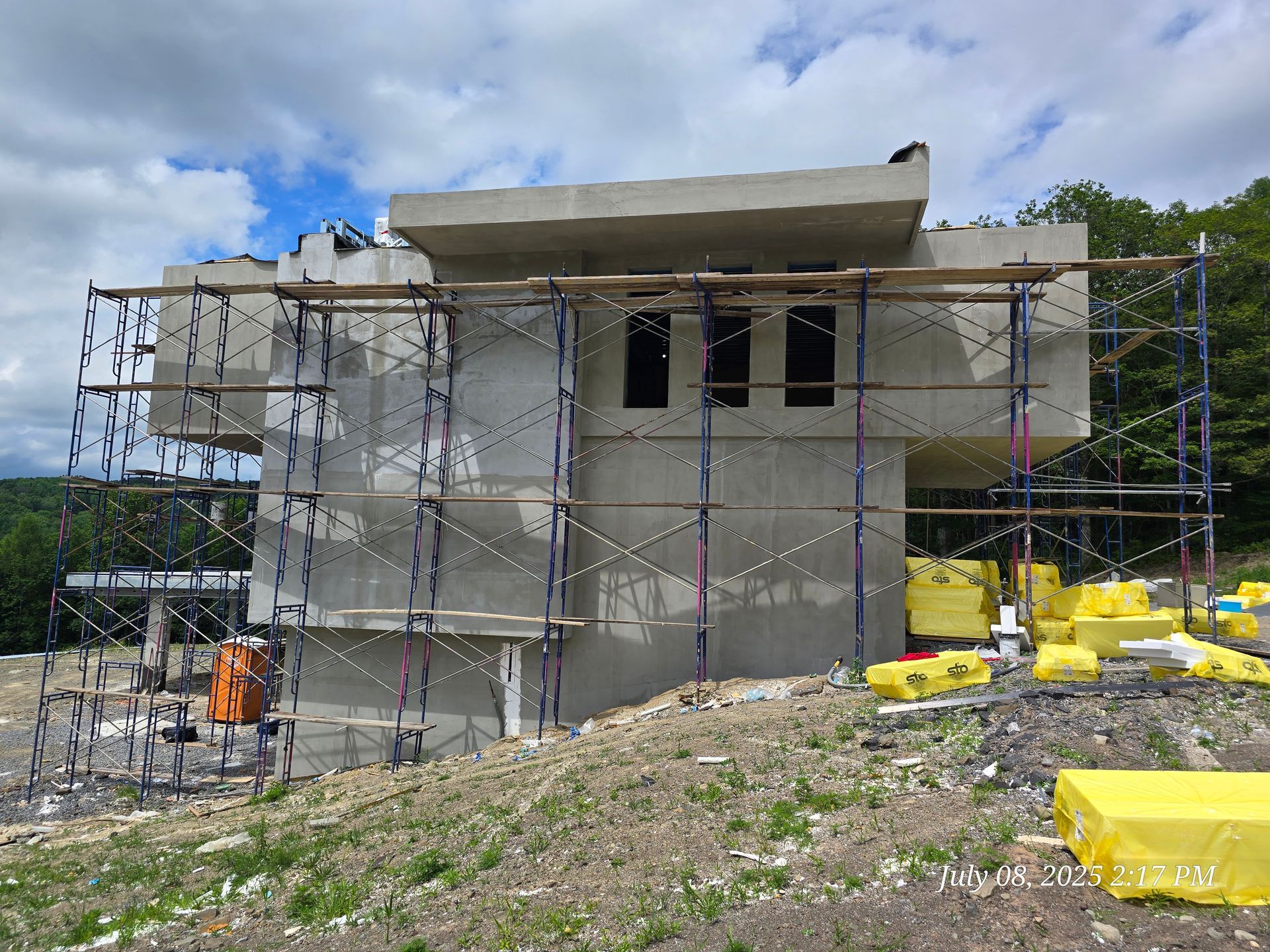 Building construction site with scaffolding, cement walls, and insulation.
