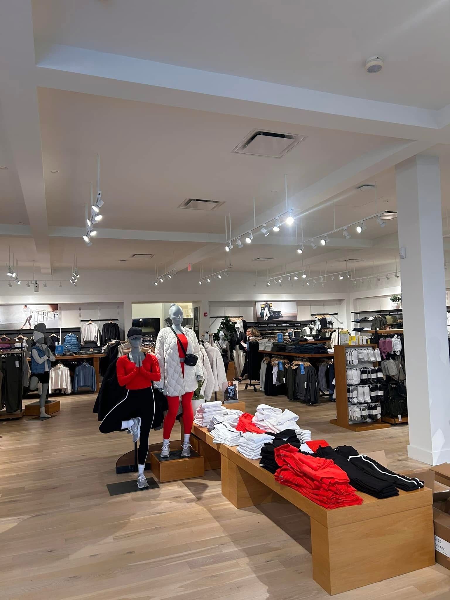 A large clothing store filled with lots of clothes and mannequins.