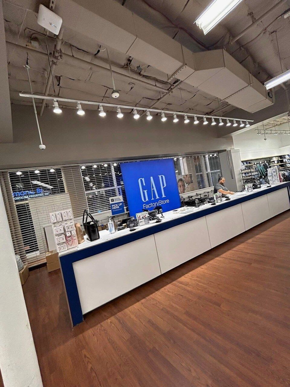 A gap store with a long counter and a blue sign on the wall.