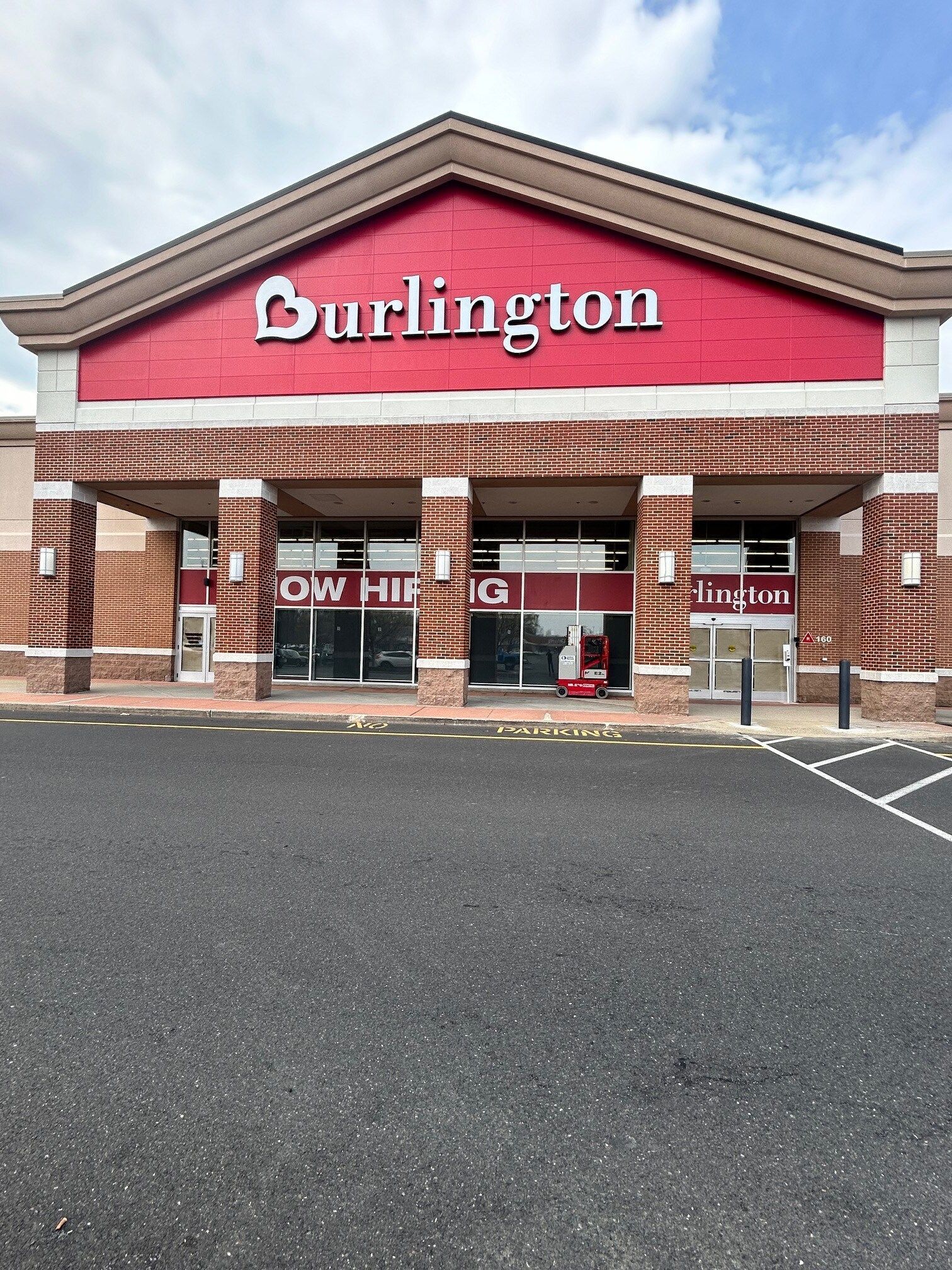 The front of a burlington store with a parking lot in front of it.