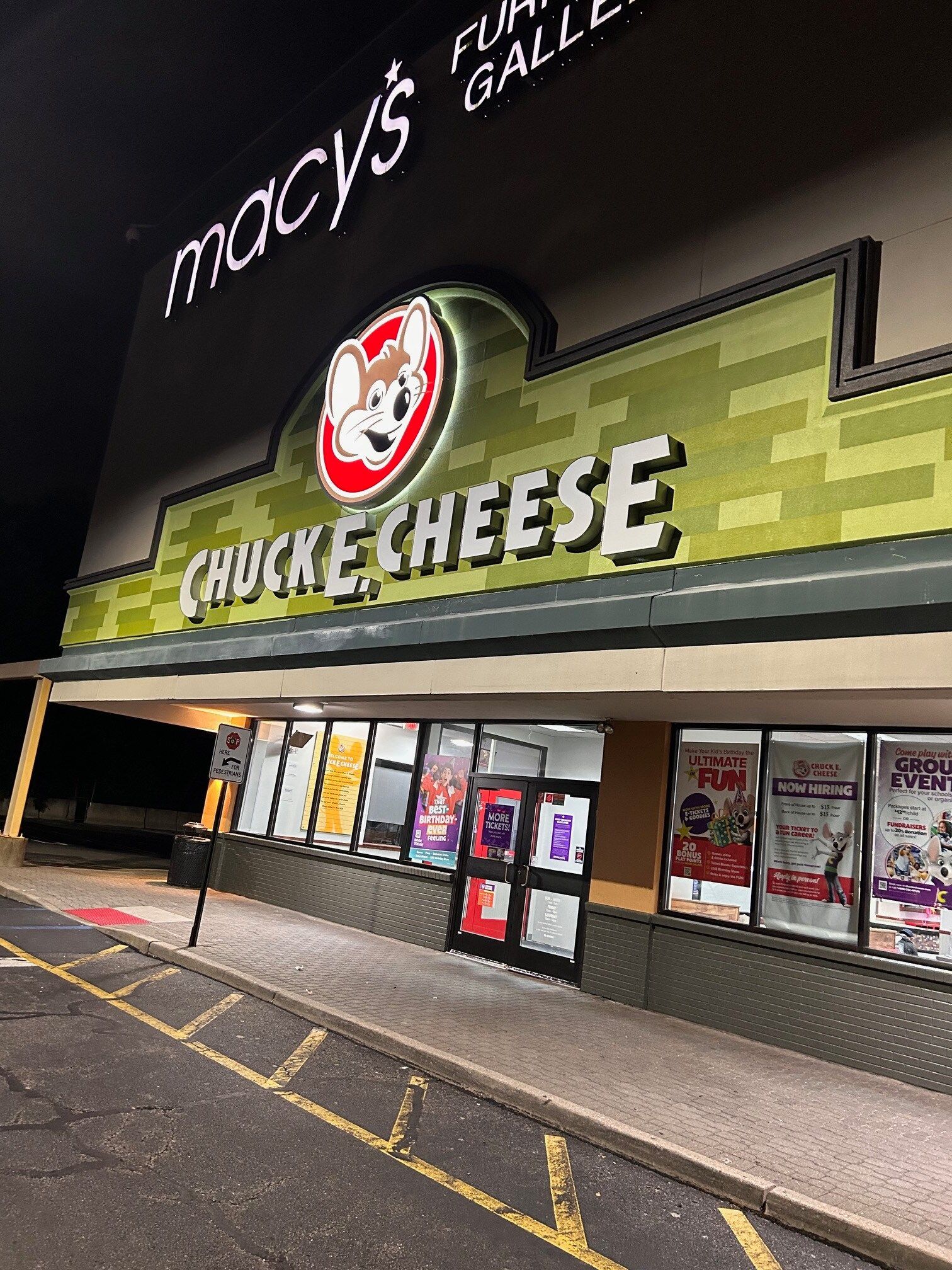 The front of a chuck e cheese restaurant at night.
