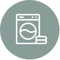 Washing machine icon with clean towels on a green background.