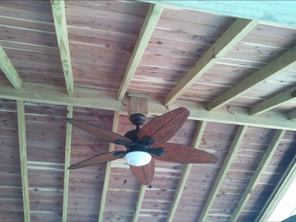 Ceiling fan on a wood-planked outdoor porch ceiling.