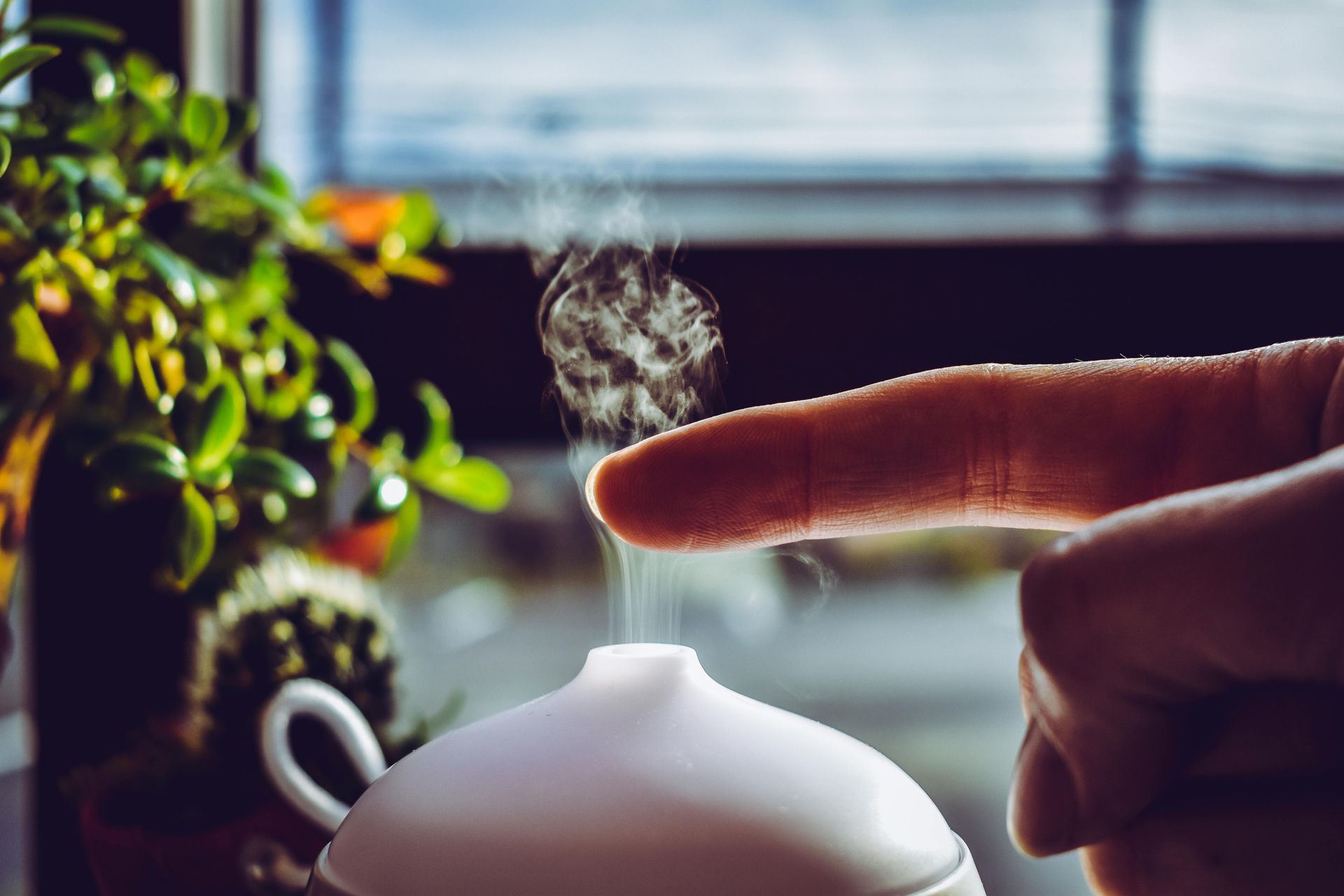 Hand adjusting a home humidifier during a Minnesota winter to maintain proper indoor humidity levels