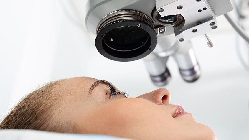 Patient lying under an eye examination microscope during a medical exam