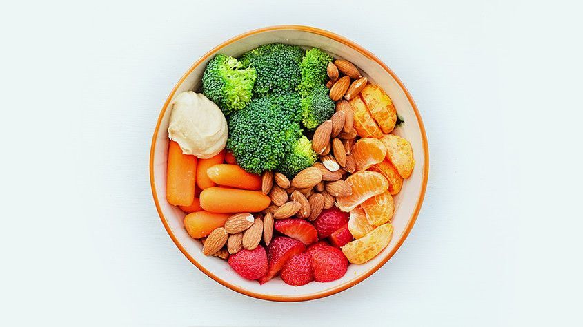 Overhead view of a bowl with broccoli, carrots, potatoes, almonds, shrimp, and strawberries
