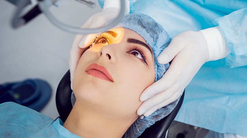 Clinician examining a patient's eye with a bright light in a medical setting