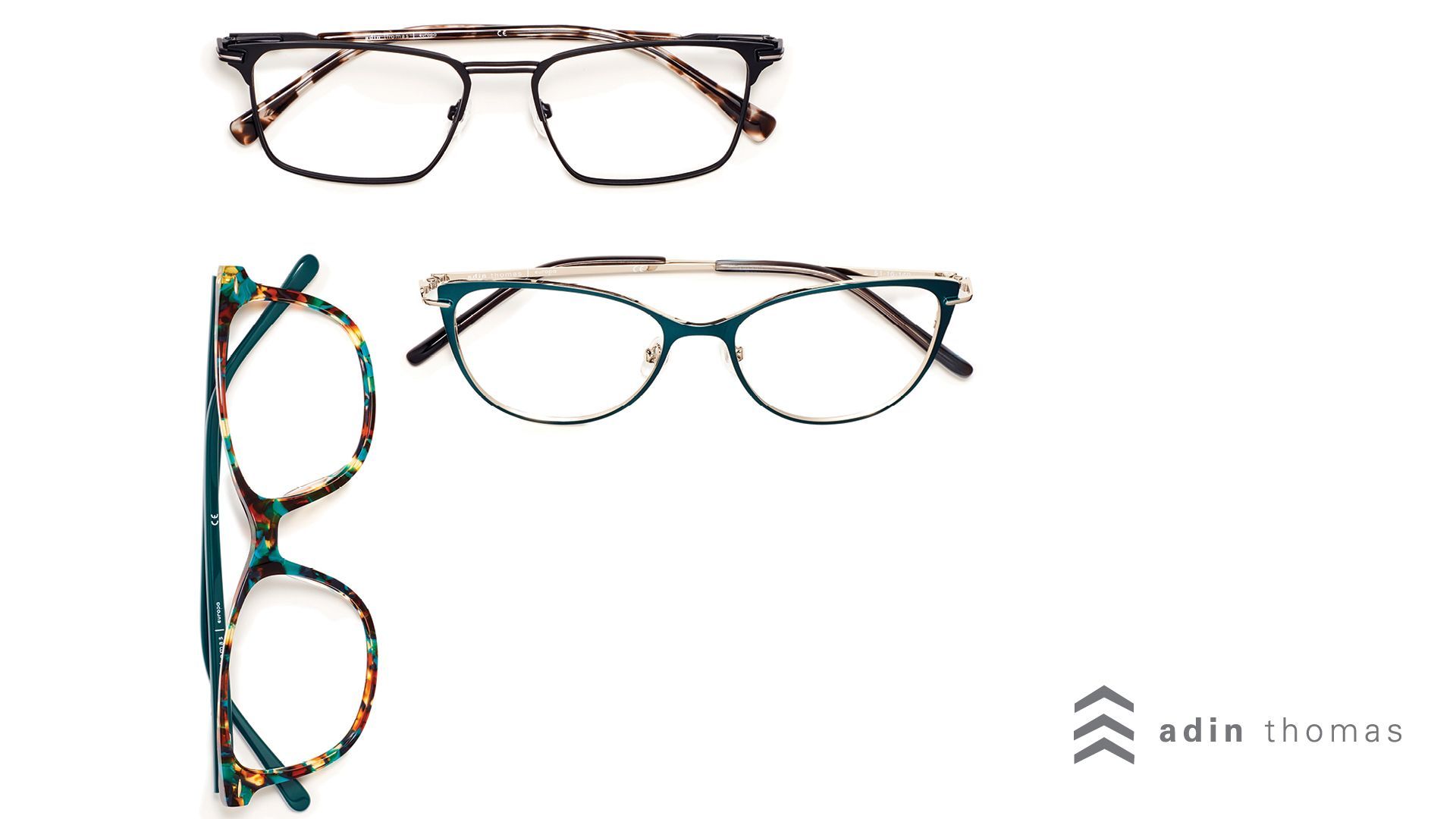Red eyeglasses on top of a sheet with eyeglass sketches and measurements