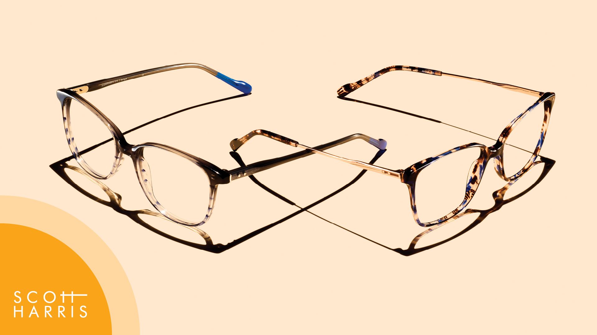 Red eyeglasses on top of a sheet with eyeglass sketches and measurements